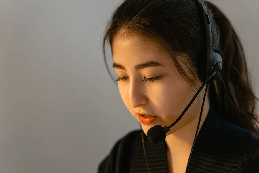 A specialist wearing a telephone headset, listening on a call