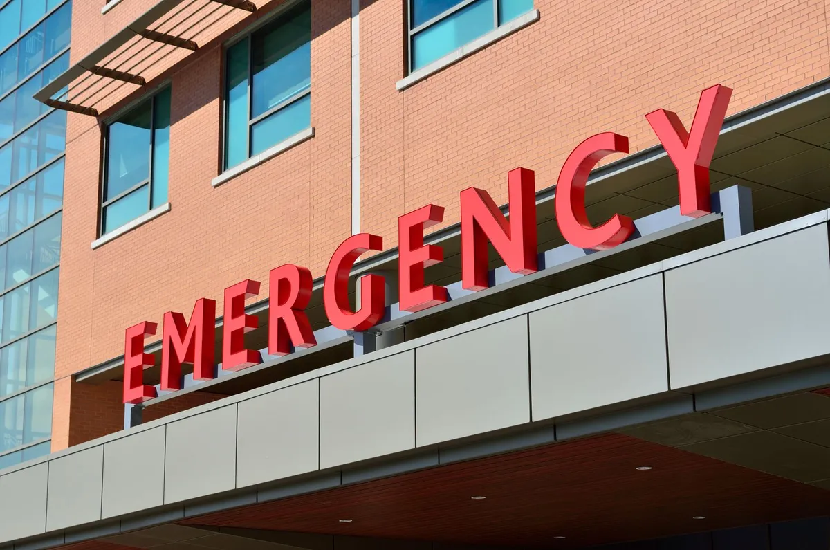 Red EMERGENCY letters over a hospital emergency entrance