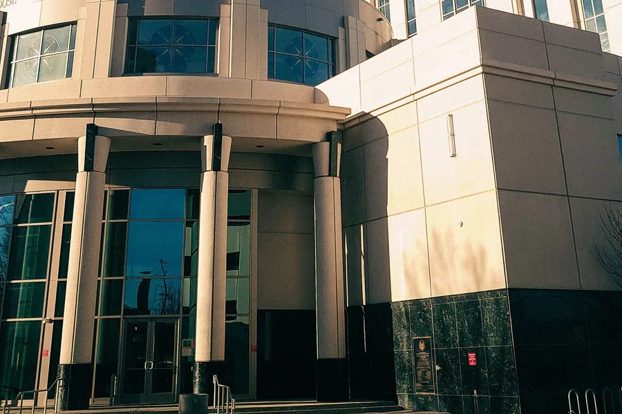 The columned entrance of a county courthouse under a clear sky