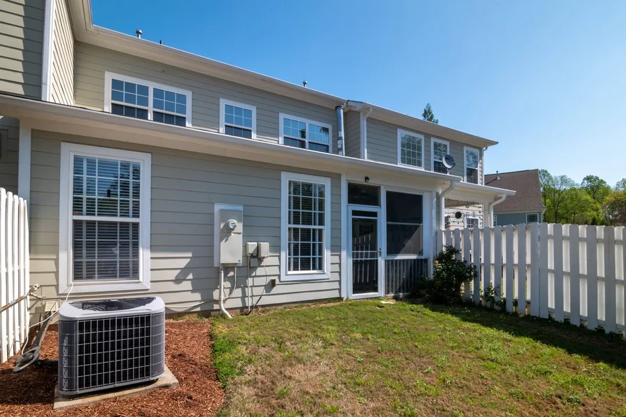 The back of a suburban American house showing the outdoor air conditioning unit and the electric meter