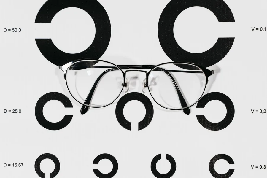 A pair of eyeglasses resting on a printed eye chart